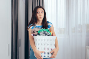 Women making a worried face and holding a basket of laundry