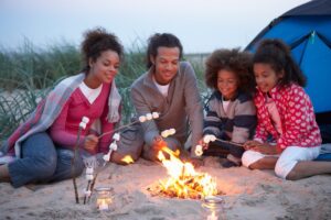 family roasting marshmallows around a campfire