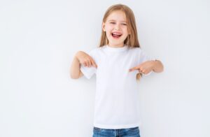 happy girl pointing to the bright white shirt she is wearing
